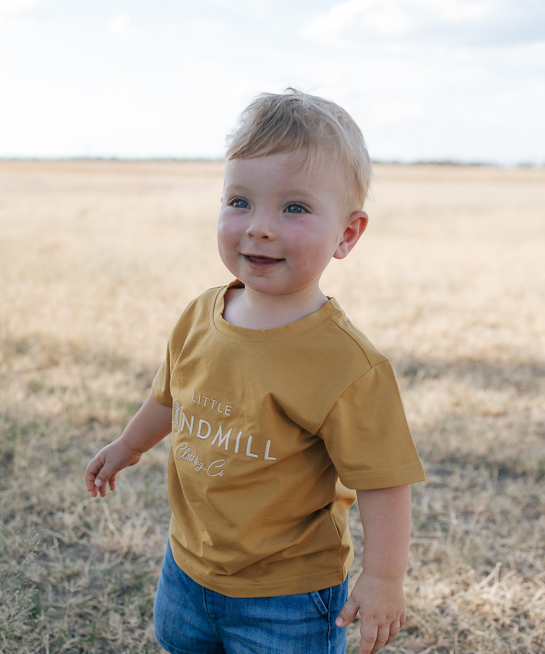 LWCC embroidered kids tee mustard front view showing signature LWCC embroidered logo on warm mustard
