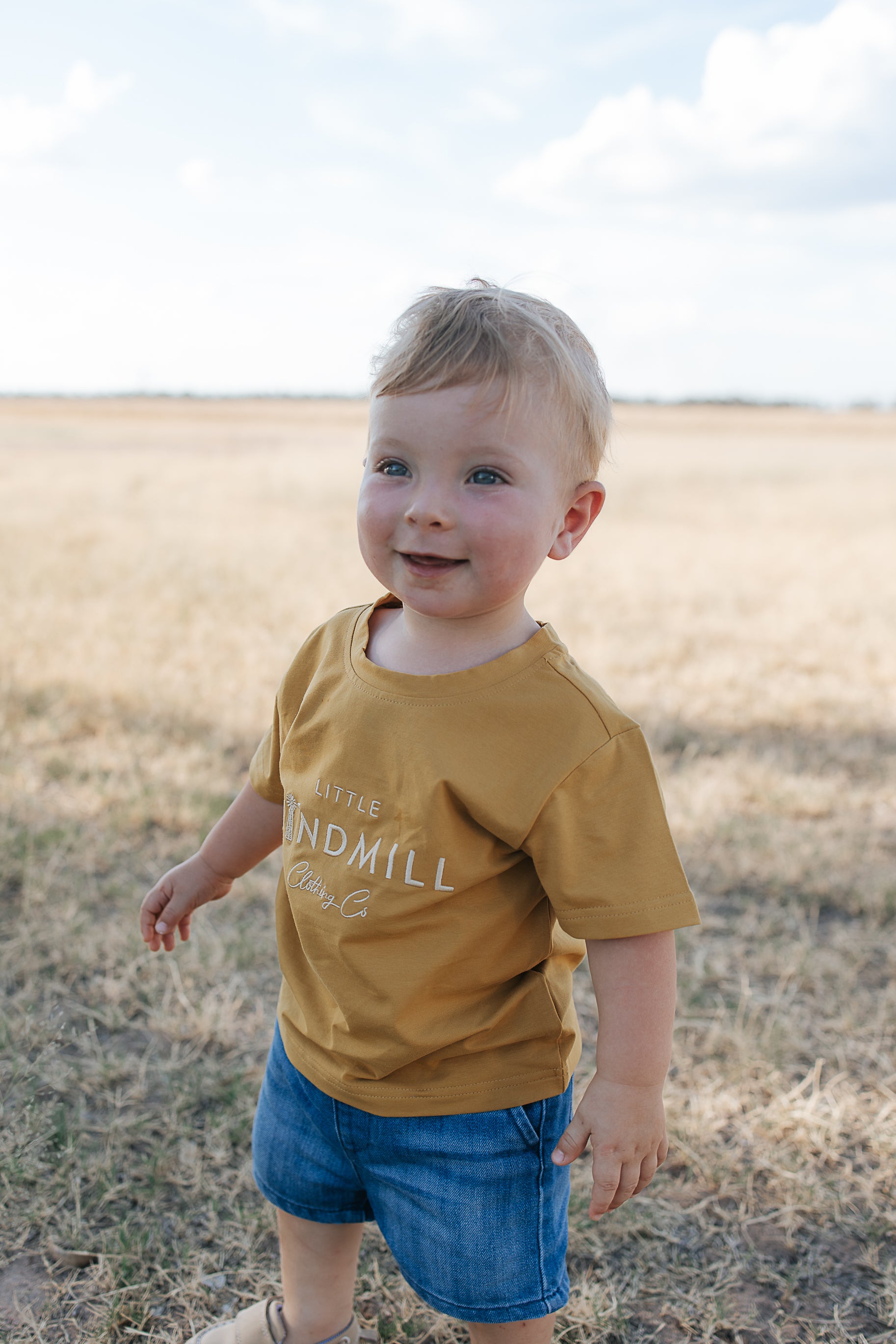 LWCC embroidered kids tee mustard front view showing signature LWCC embroidered logo on warm mustard