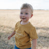 LWCC embroidered kids tee mustard front view showing signature LWCC embroidered logo on warm mustard