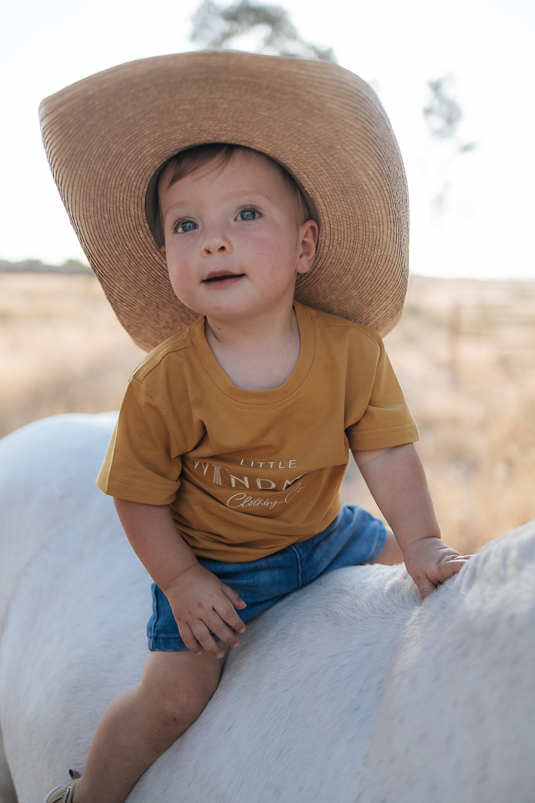 LWCC embroidered kids tee mustard flatlay showing full design and vibrant mustard colourway