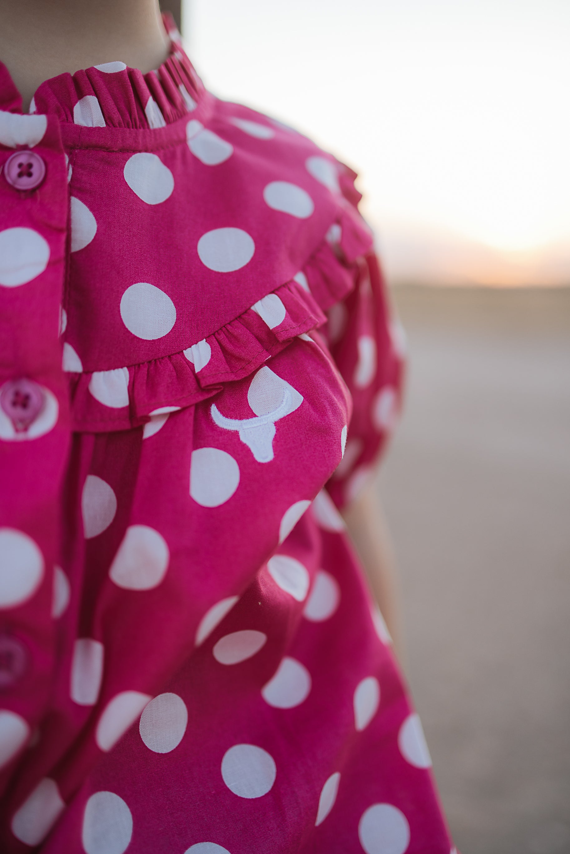 Kansas polkadot pink short sleeve blouse worn by girl showing sweet playful pink polkadot style