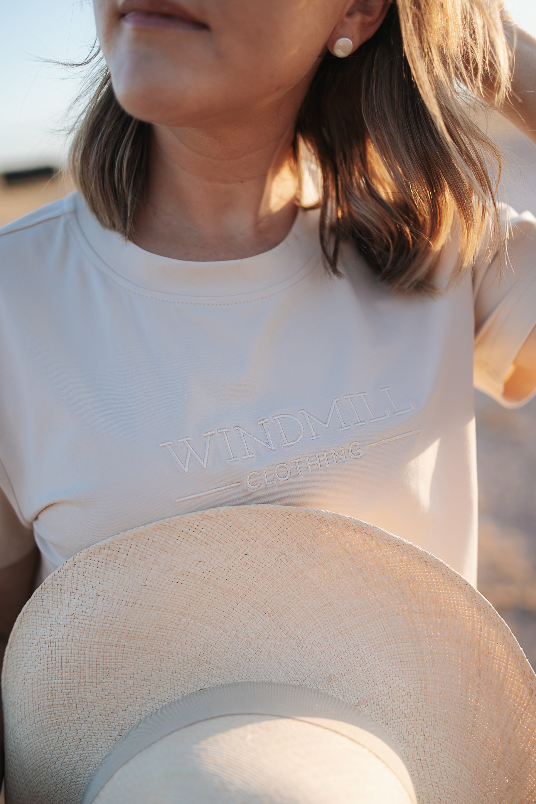 LWCC embroidered ladies tee beige embroidery close-up showing detailed LWCC logo stitch on beige