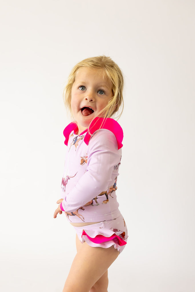 Child wearing swimmers  a pink and white outfit with a white background