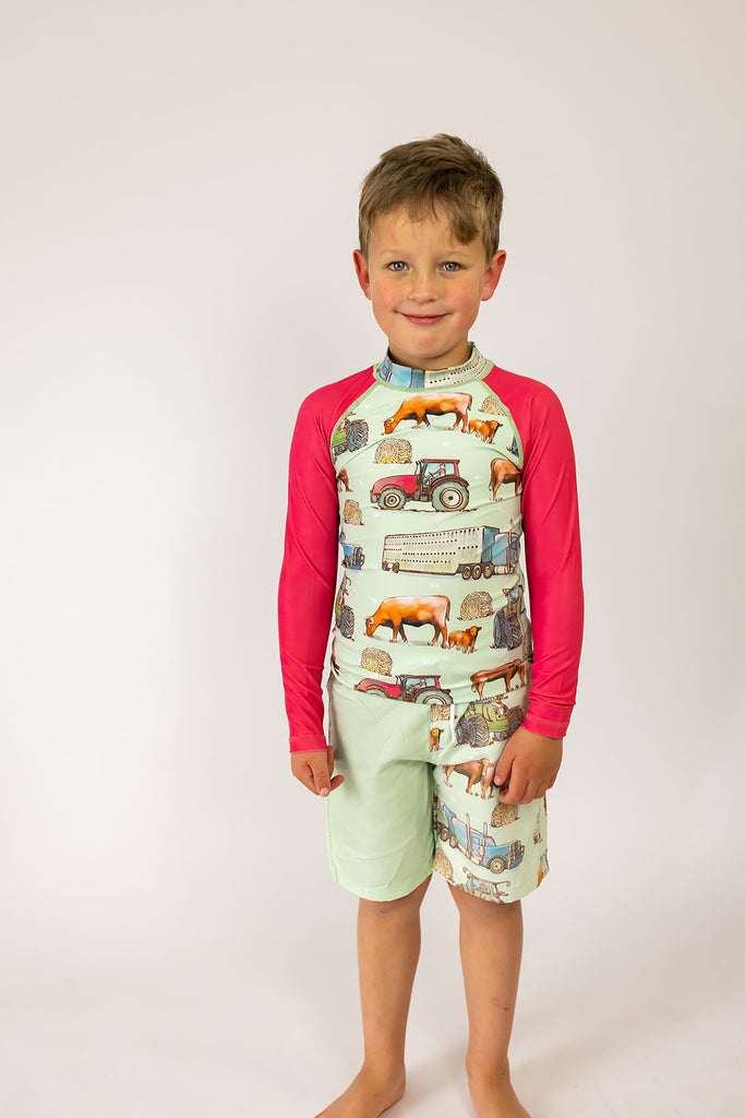 Child wearing a colorful outfit with animal illustrations on a plain background