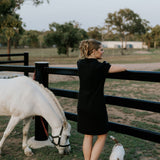 Shay semi-fitted women's black polo dress back view showing semi-fitted silhouette in classic black