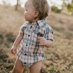 Dallas checked tan short sleeve romper flatlay showing full romper design in classic tan check