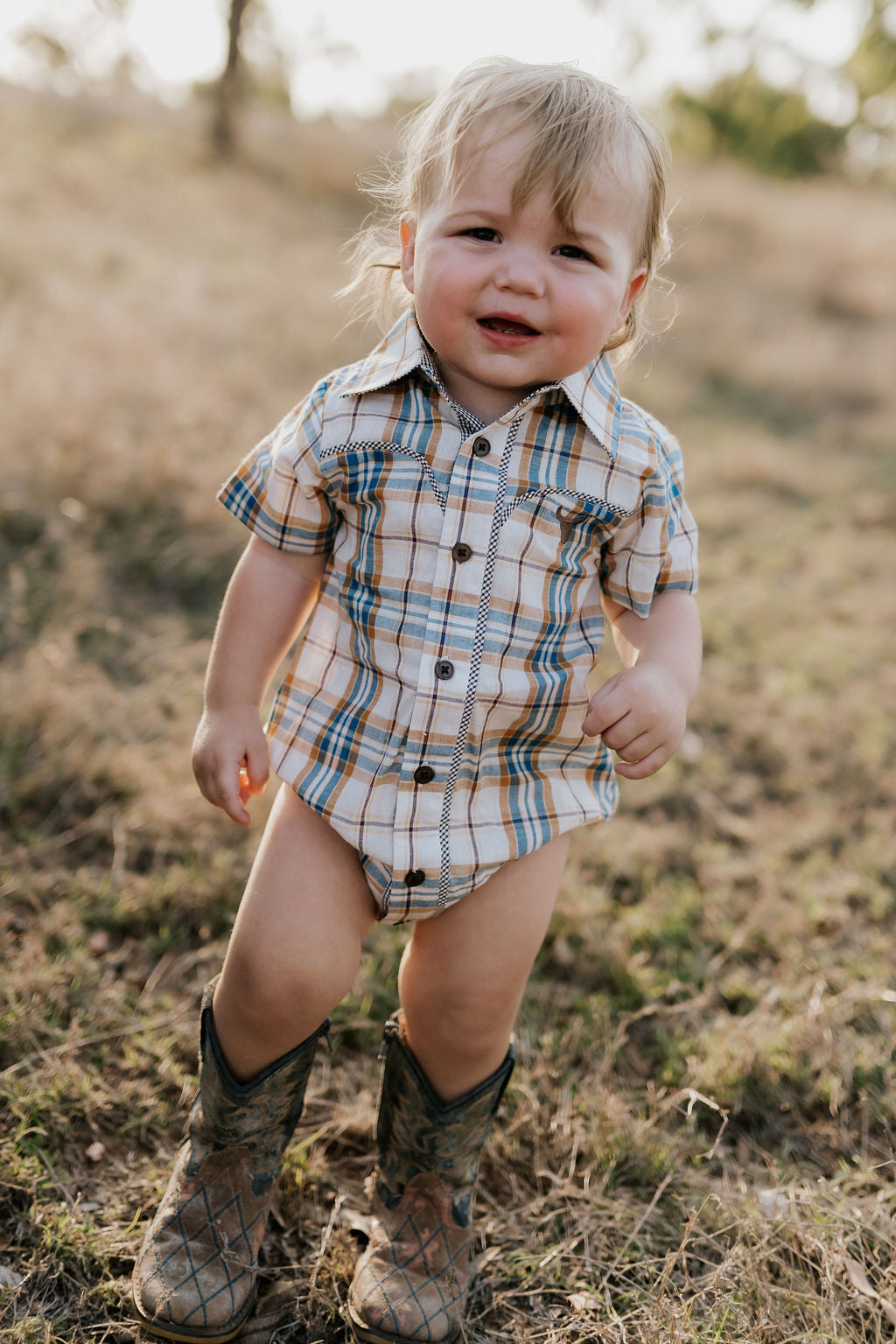 Dallas checked tan short sleeve romper back view showing snap closure and neat tan check fabric