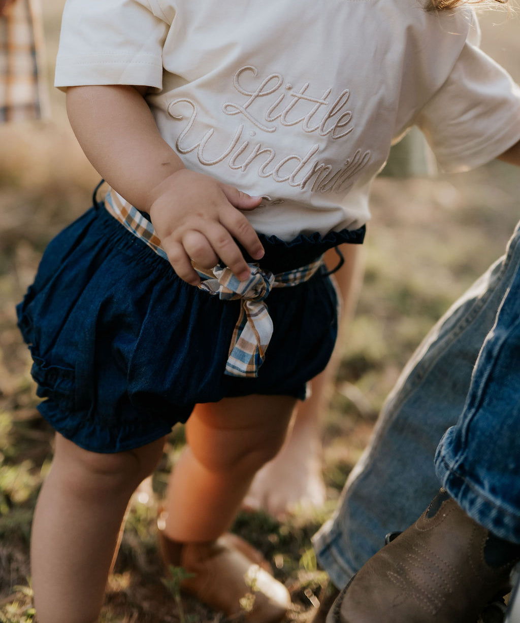 Monica denim baby bloomers with check tie front view showing sweet denim bloomer with gingham check bow