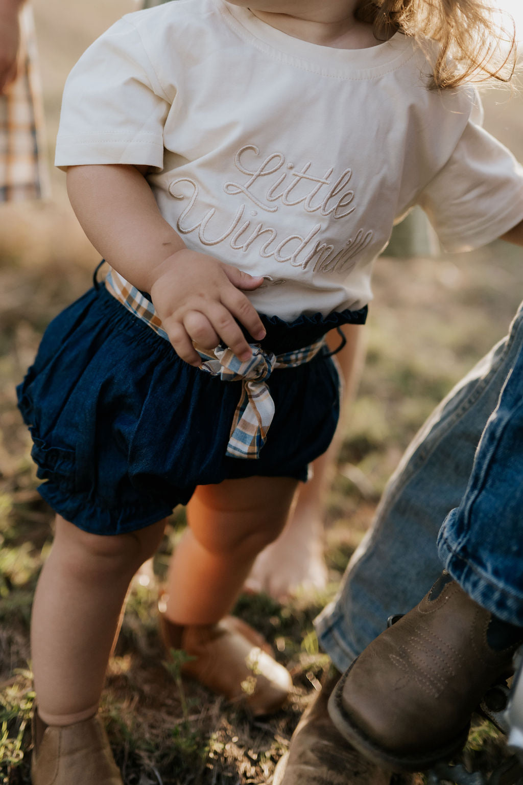 Monica denim baby bloomers with check tie front view showing sweet denim bloomer with gingham check bow