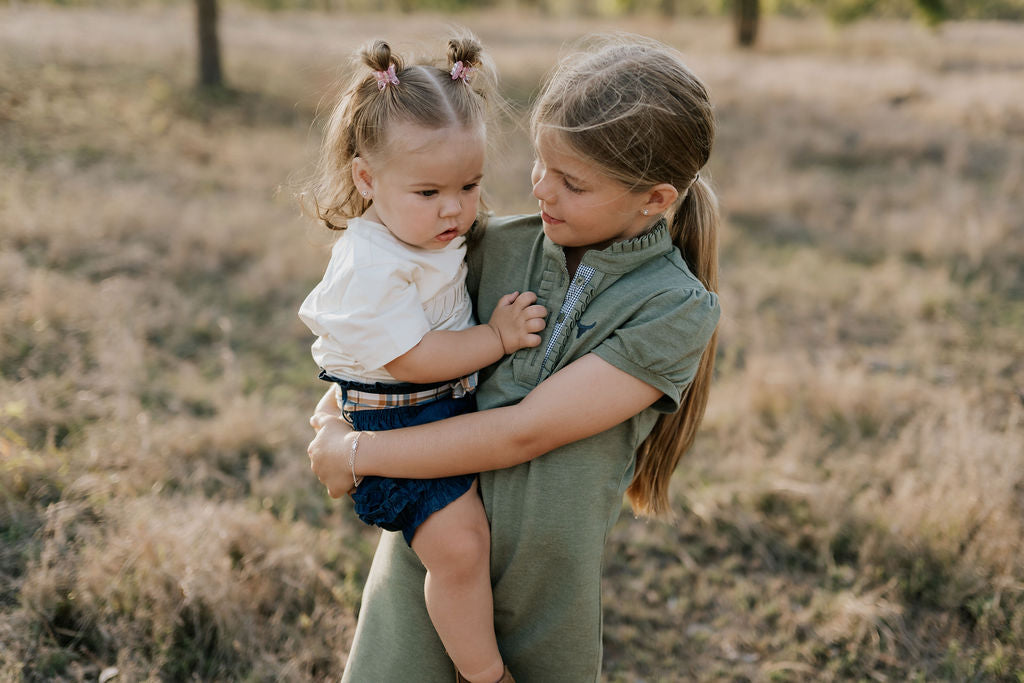 Kathy girls khaki polo dress hem detail showing quality stitching and fabric finish