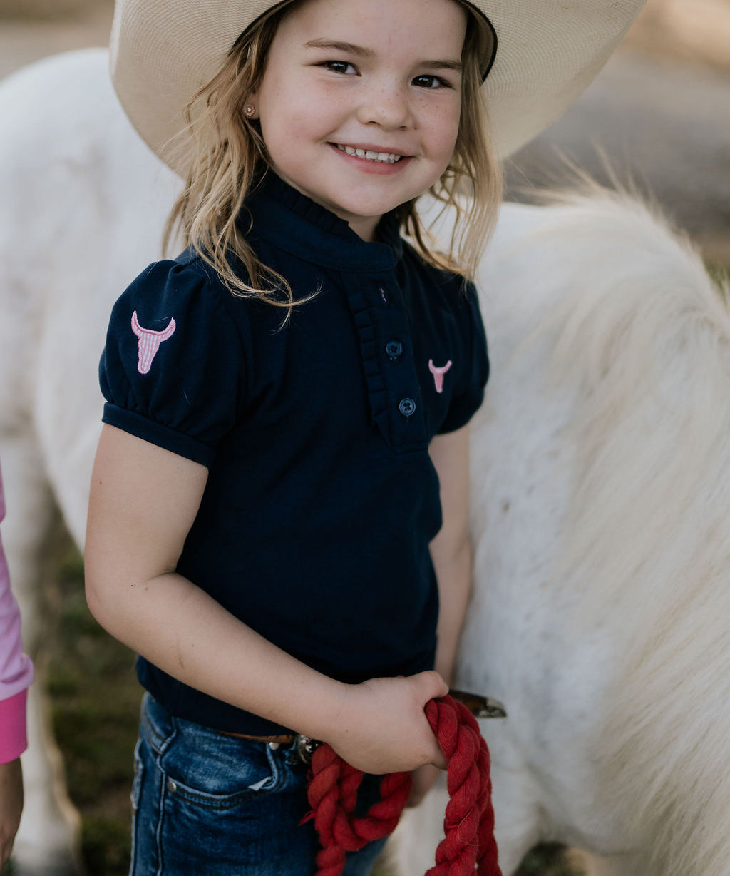 Leah classic navy ruffle polo front view showing elegant ruffle collar in classic navy with sophisticated detail