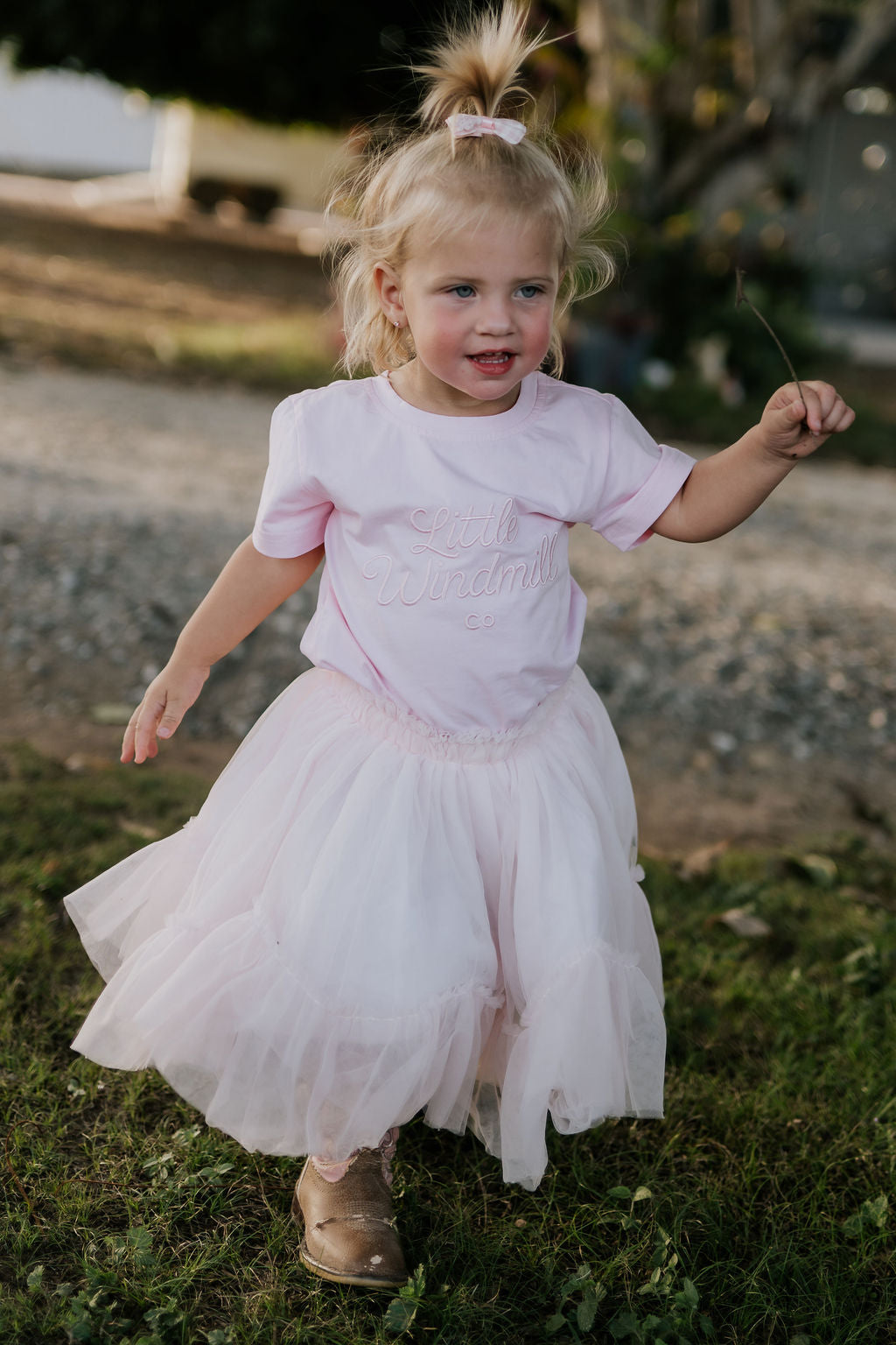 LIMITED EDITION embroidered kids tee soft pink embroidery close-up showing detailed LWCC logo stitch