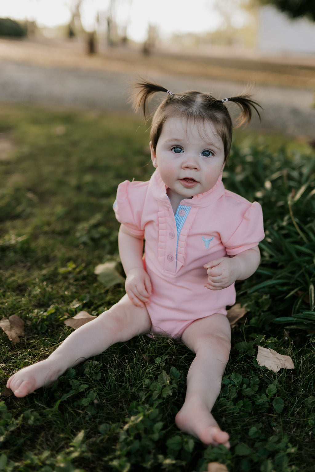Kiki Baby pink polo romper back view showing snap button closure for easy dressing