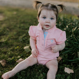 Kiki Baby pink polo romper back view showing snap button closure for easy dressing