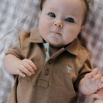 Clay Baby caramel baby polo romper front view showing warm caramel polo collar romper with snap buttons