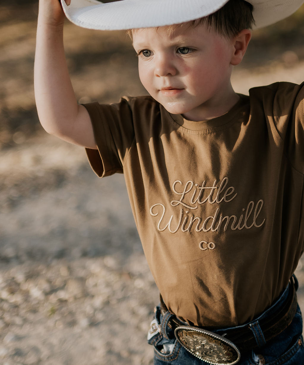 LIMITED EDITION embroidered kids tee dust brown front view showing signature LWCC logo on warm dusty brown
