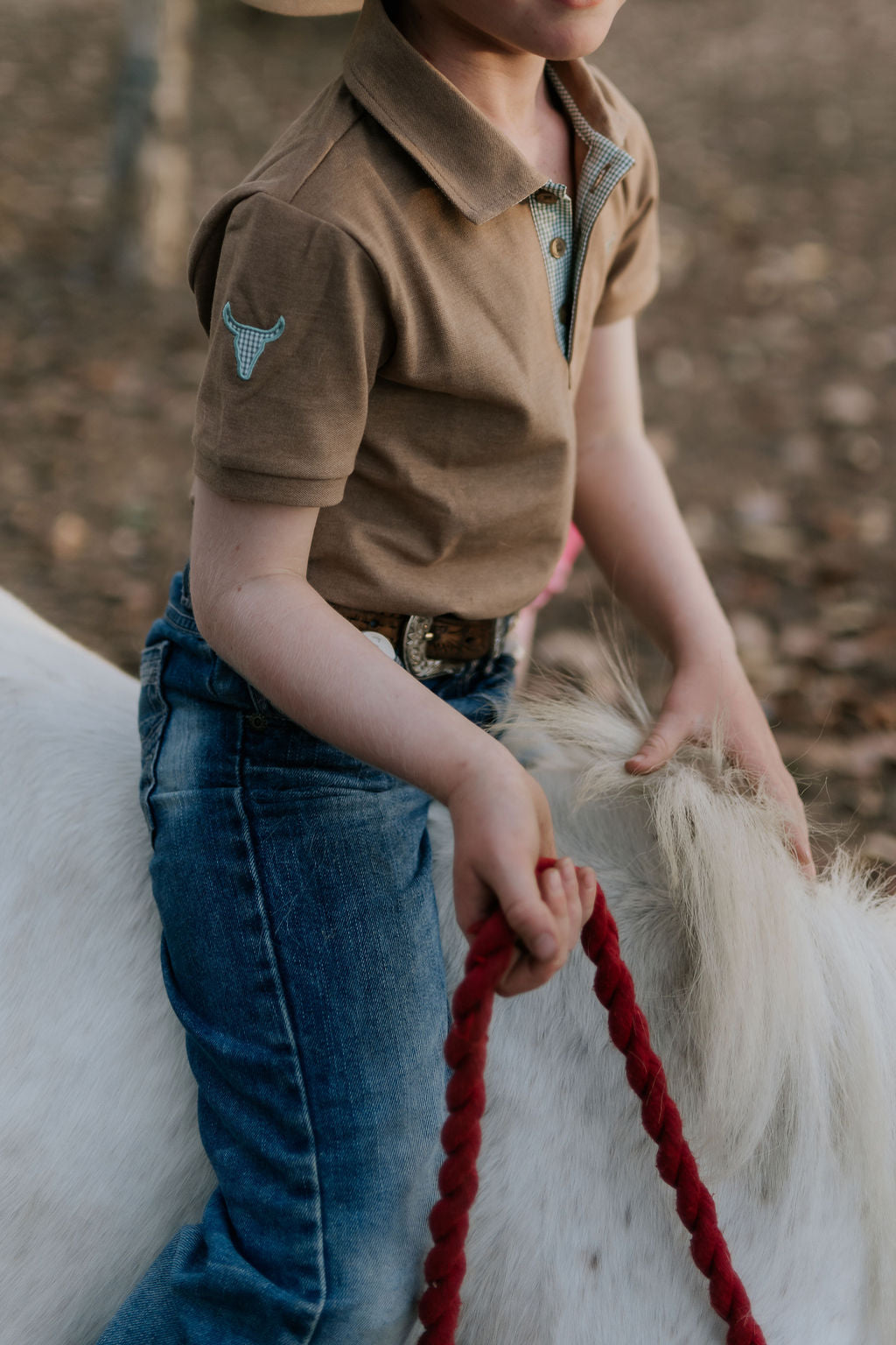 Clayton caramel boy's polo worn by boy showing smart casual country style in warm tones