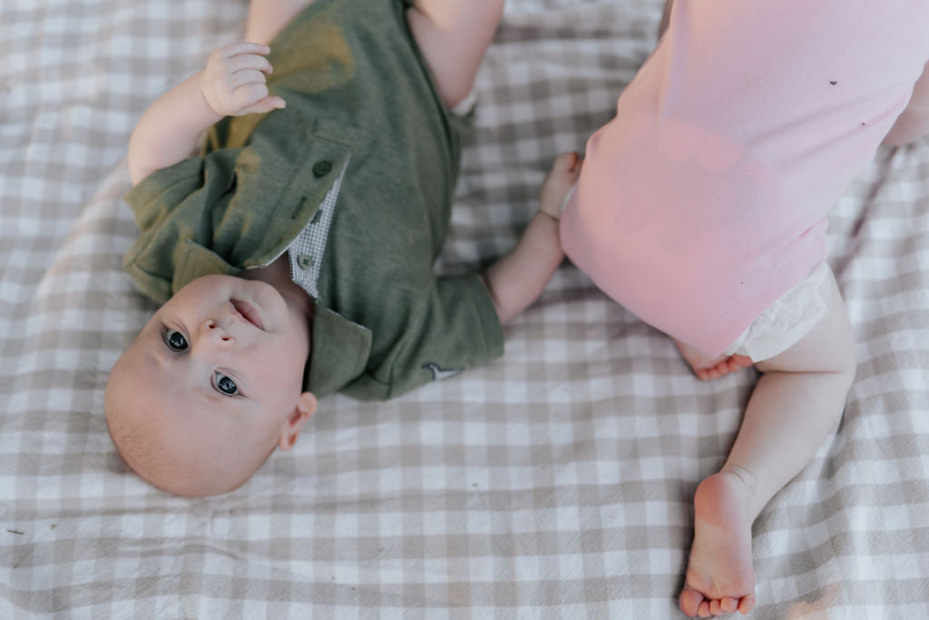 Kiki Baby pink polo romper snap detail showing easy nappy change access