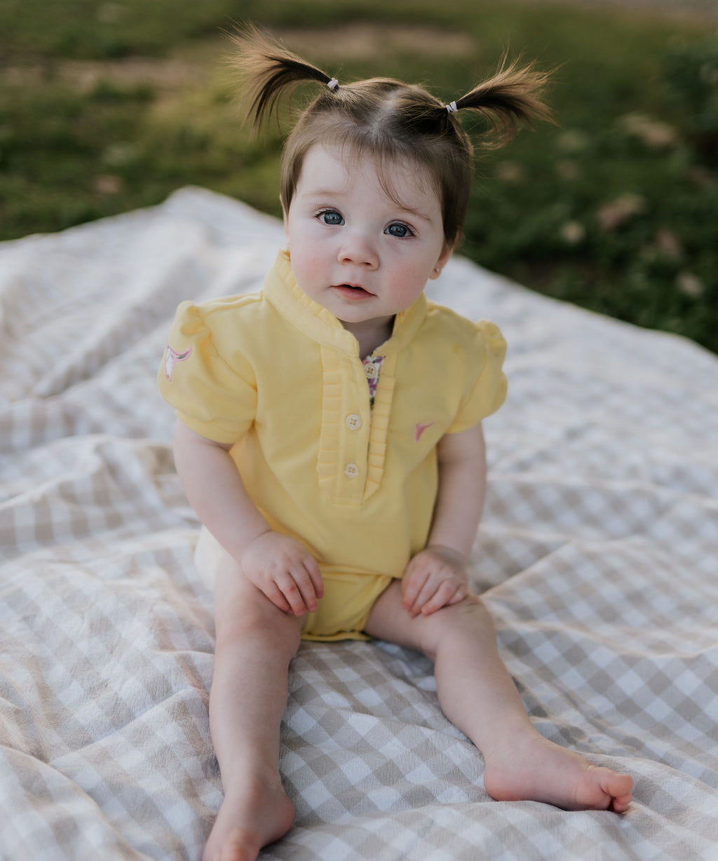 Larrisa Baby butter yellow polo romper back view showing snap button closure and yellow colourway