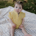 Larrisa Baby butter yellow polo romper back view showing snap button closure and yellow colourway