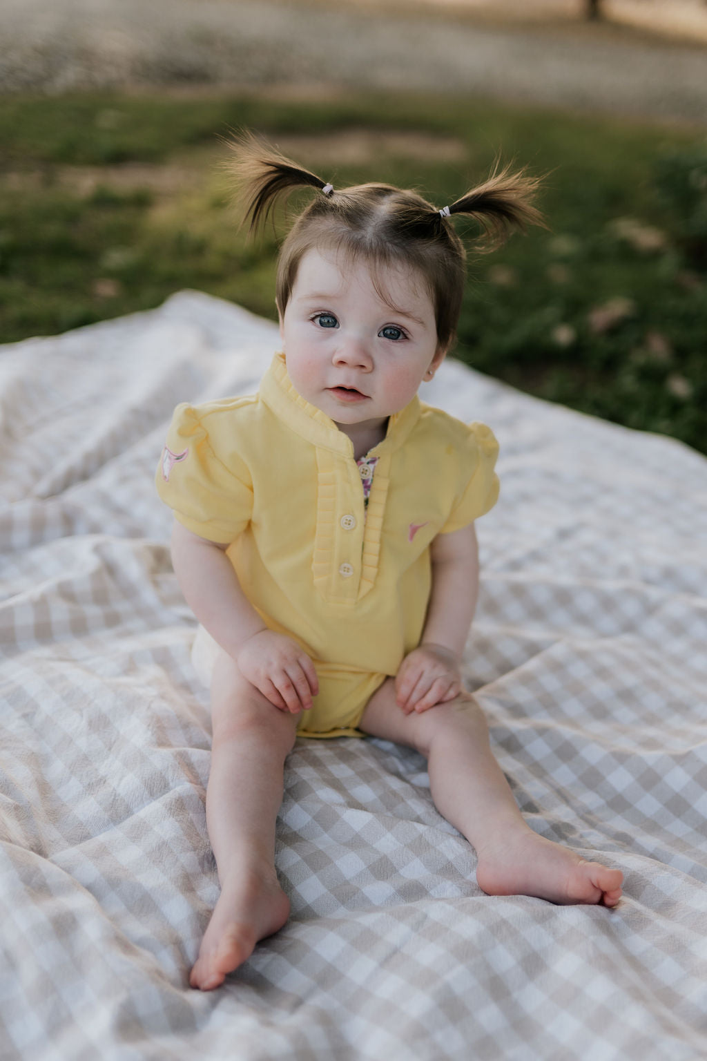 Larrisa Baby butter yellow polo romper back view showing snap button closure and yellow colourway