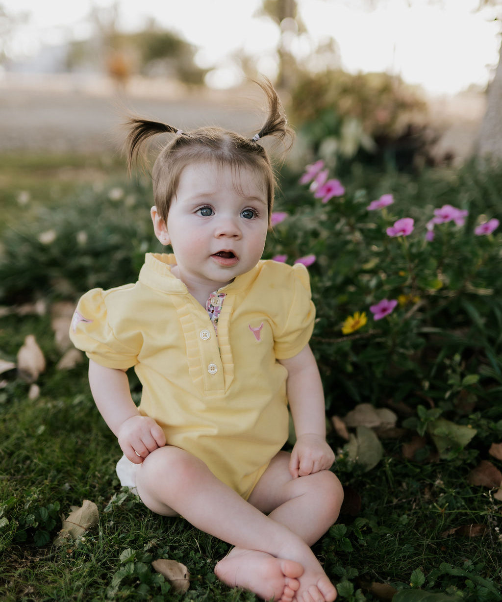 Larrisa Baby butter yellow polo romper front view showing cheerful butter yellow polo collar romper with snap buttons