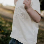 LIMITED EDITION embroidered kids tee cream front view showing signature LWCC embroidered logo on classic cream