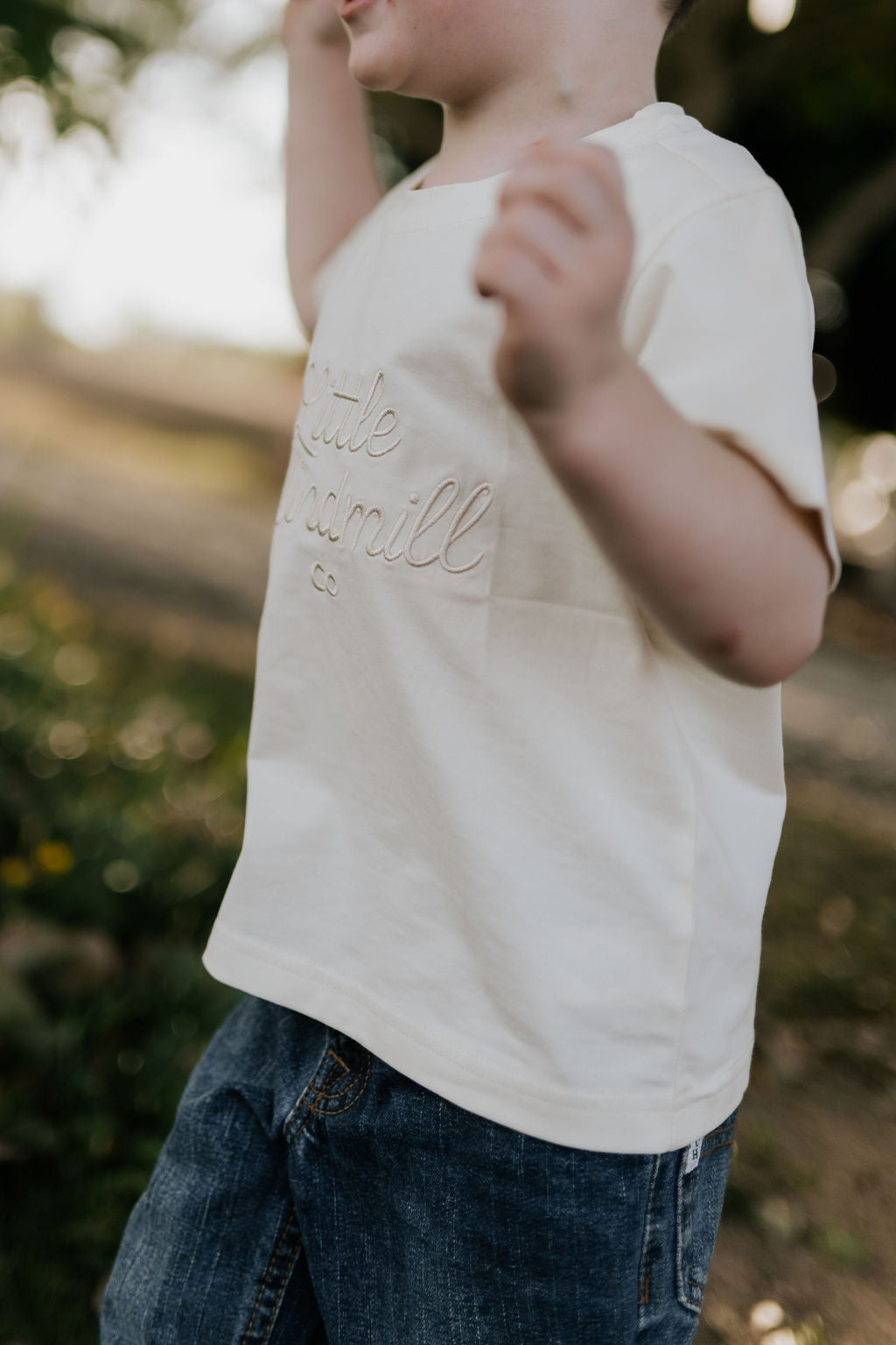 LIMITED EDITION embroidered kids tee cream front view showing signature LWCC embroidered logo on classic cream