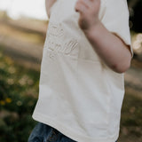 LIMITED EDITION embroidered kids tee cream front view showing signature LWCC embroidered logo on classic cream