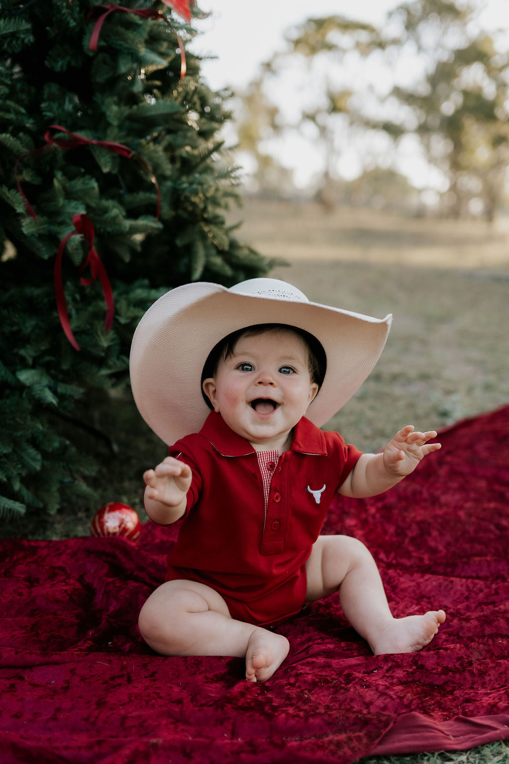 Nicco Baby deep red polo romper worn by baby showing sweet matching family polo style