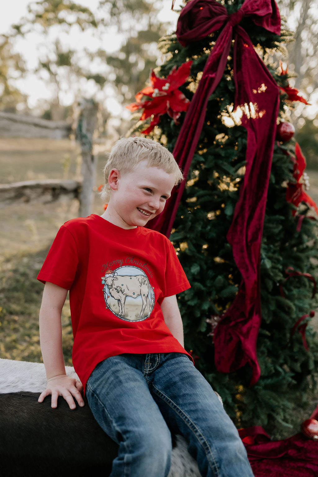 Western printed Christmas cow tee front view showing festive Christmas cow and western holiday print