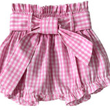 Pink gingham check baby bloomers with a bow on a gray background