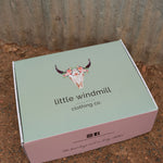 Branded gift box with ribbon and branded tissue paper containing newborn Huggies nappies and arranged on recycled filling