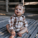 Baby boy in a brown check long-sleeve romper