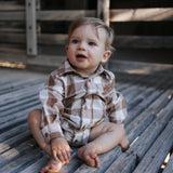 Baby boy in a brown check long-sleeve romper