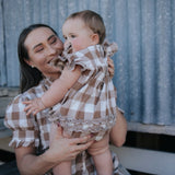 Mum holding baby girl in a brown gingham ruffle romper