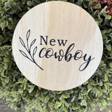 Engraved round cowboy wooden plaque with "New cowboy" text on natural pine wood