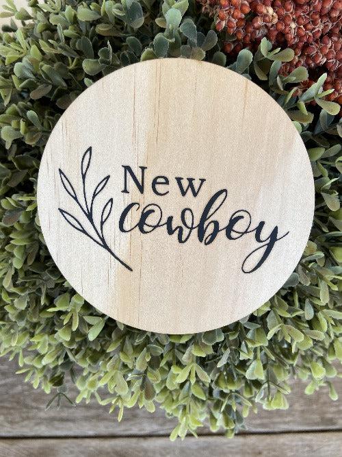 Engraved round cowboy wooden plaque with "New cowboy" text on natural pine wood