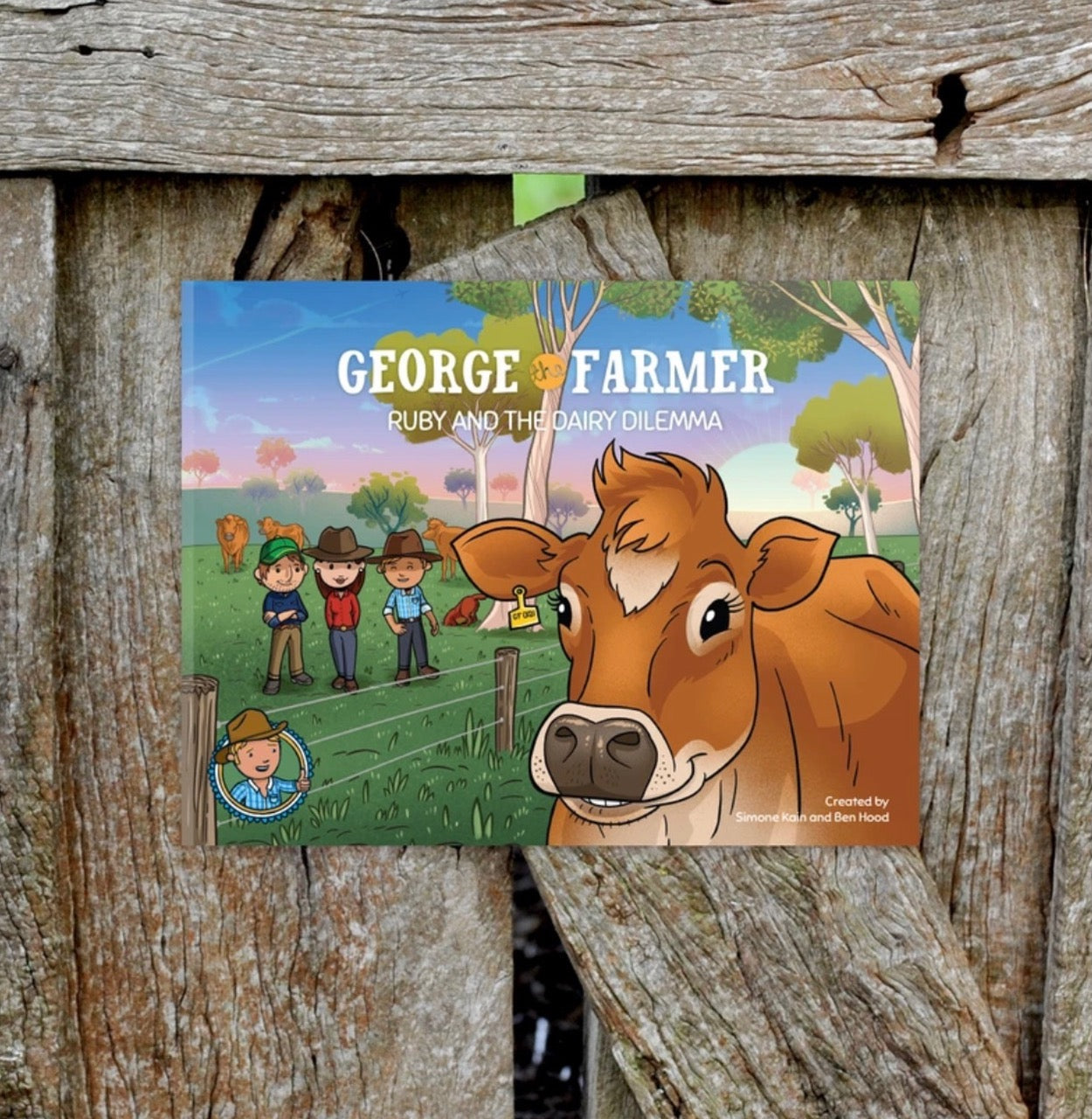 Cover of George the Farmer children’s book featuring a cow and three farmers in a rural landscape